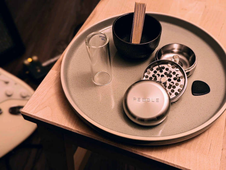 Pebble lifestyle image showing the Pebble Grinder in a dark guitar studio setting